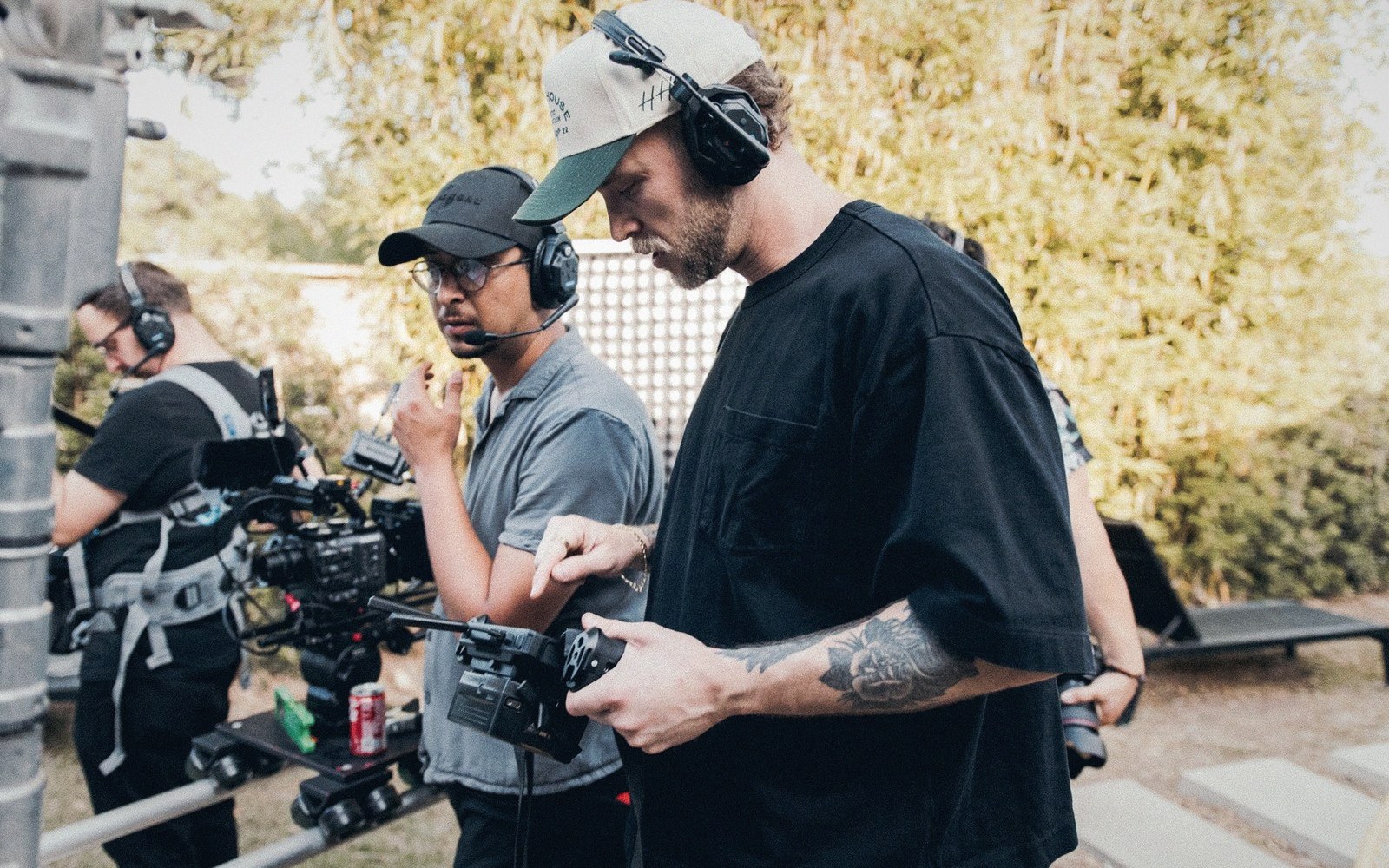 Crew members wearing headphones operate camera equipment on an outdoor film set